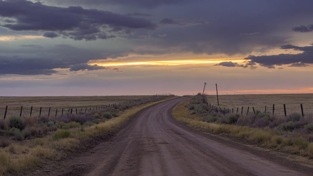 Country road under breaking storm light