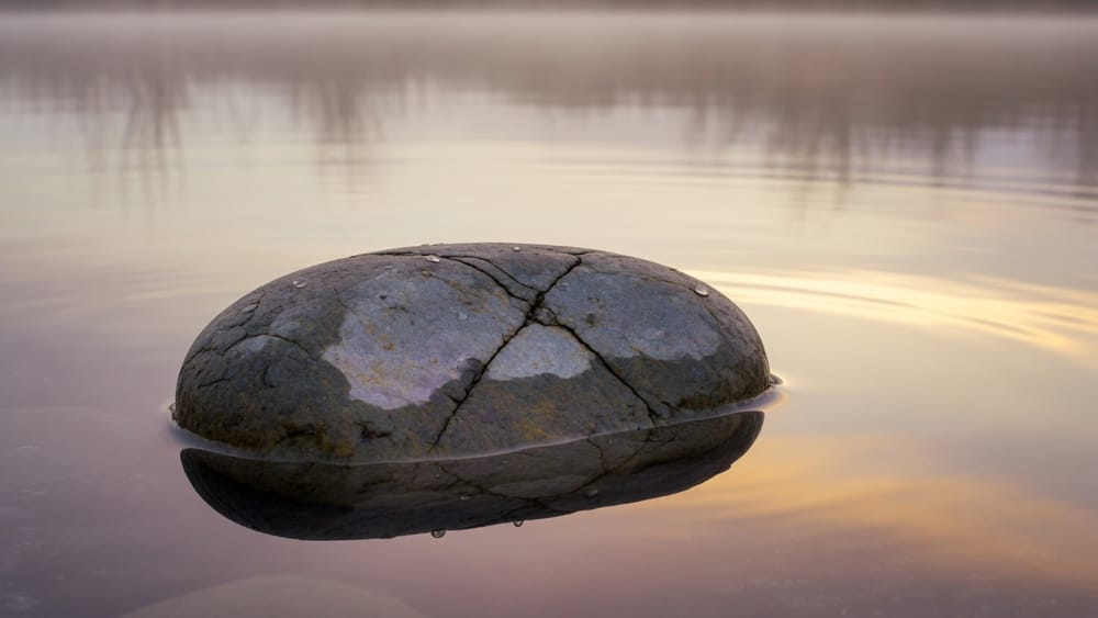 A cracked stone in still water